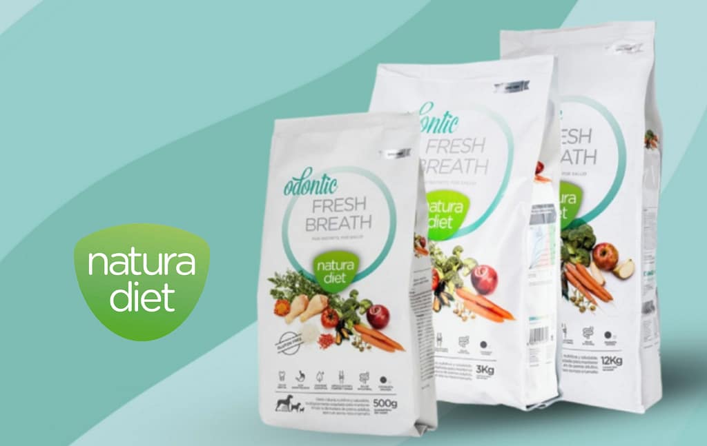 Sacs de nourriture pour chien Natura Diet Odontic Fresh Breath, gammes 500 g, 3 kg et 12 kg, avec ingrédients naturels (carottes, pommes, légumes) sur fond vert et logo Natura Diet